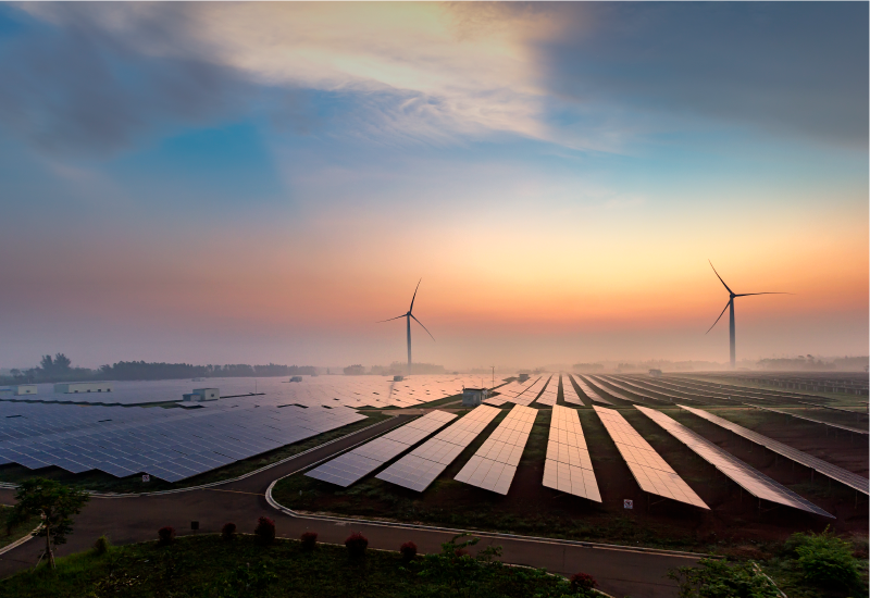 Landscape at sunset with solar panels and wind turbines